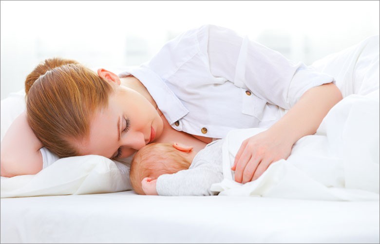 Mom lying down with newborn breastfeeding