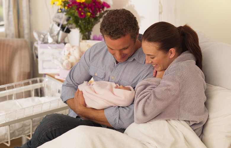 Mom and Dad in hospital holding newborn