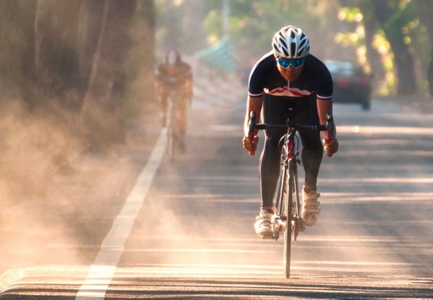 Male riding a bike on a street.