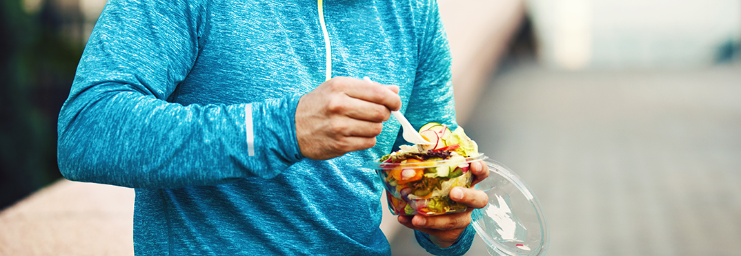 Man eating a salad after working out.