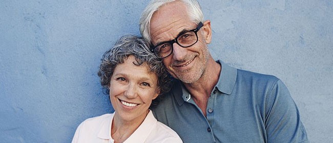 Senior couple in front of a blue wall