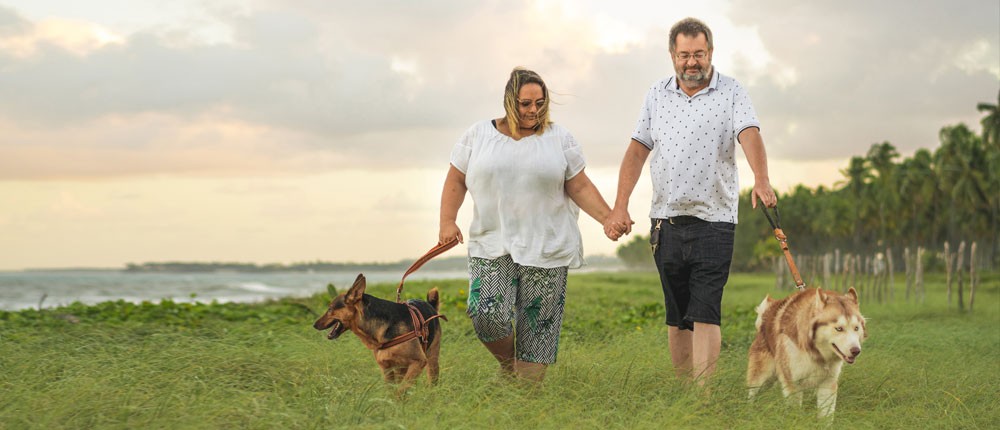 Couple walking their dogs near water